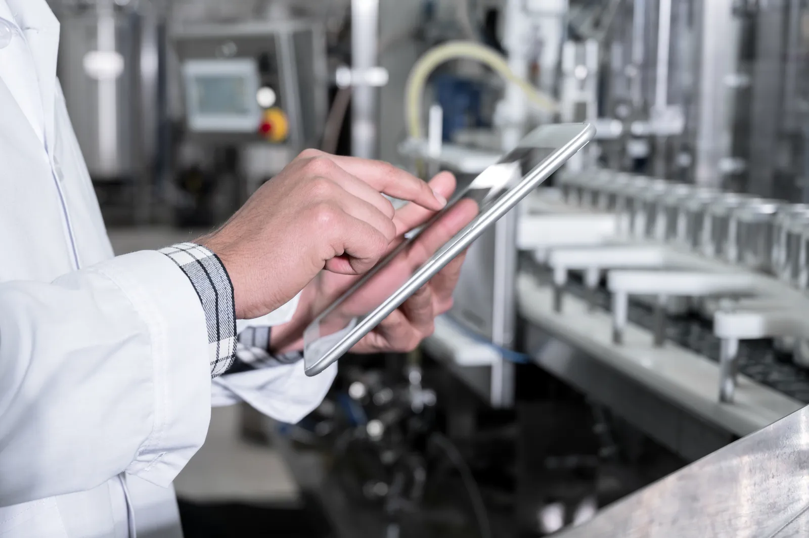 Quality inspector checking a production line with a tablet